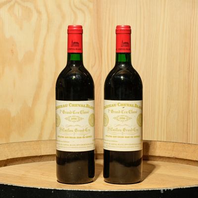 two bottles of wine sitting on top of a barrel