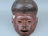 gros plan d'un masque en bois sur une surface blanche