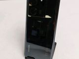 the back of a black phone sitting on top of a white table