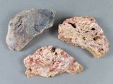 trois morceaux de roche posés sur une table, sur fond gris