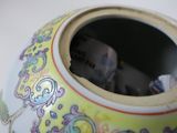 a yellow vase with a picture of a woman in it