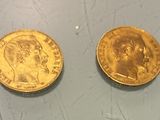 two gold coins sitting next to each other on top of a table