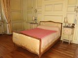 a bed with a pink blanket on it in a room