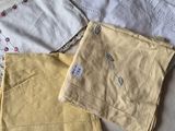 three pairs of yellow pants sitting on top of a bed next to each other