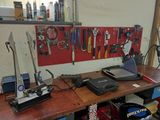 a workbench with tools and a laptop on it