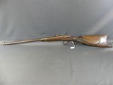an old rifle with a wooden barrel and a metal handle