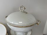 a white and gold tureeny dish with a lid