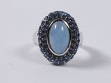 a ring with a blue stone surrounded by blue sapphires