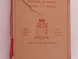 un livre marron à la couverture rouge posé sur une surface blanche