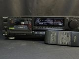 two remote controls and a radio on a table