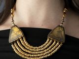 a close up of a woman wearing a black top and a gold necklace