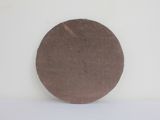 a brown disc sitting on a white surface next to a white wall