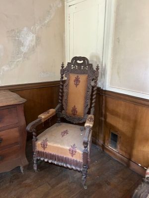 une chaise et une commode dans un coin de la pièce