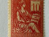 an old red stamp with a picture of a woman sitting on a chair