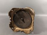 an antique brass clock on a white surface with a gray background