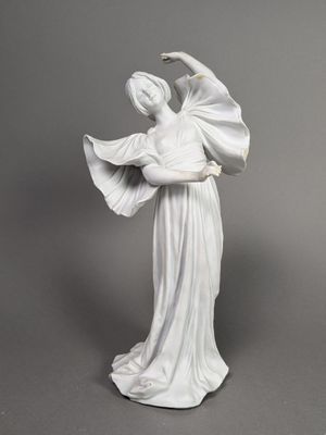 statue d'une femme en robe blanche tenant un éventail