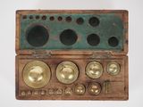 a wooden box that has a bunch of brass objects inside of it