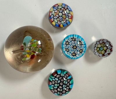 cinq aimants en verre de couleurs différentes sur une surface blanche