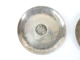 two silver plates that are sitting next to each other