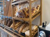 shelves of bread and pastries in a bakery with a coffee maker