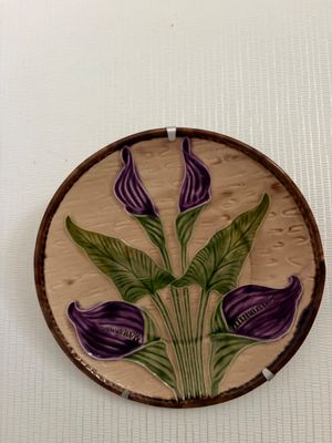 une photo d'une fleur violette et verte posée sur une assiette marron