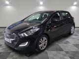 la voiture noire est garée sur un sol en damier dans le garage