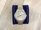 wrist watch on a blue velvet cuff with roman numerals