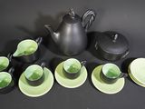 several cups and saucers are arranged next to a teapot