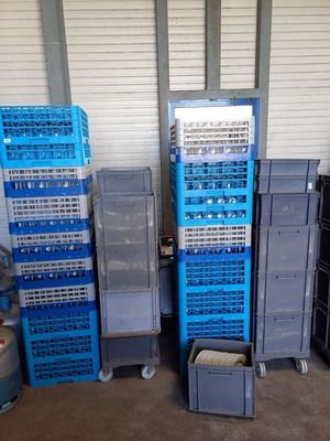 de nombreuses caisses bleues empilées les unes sur les autres dans un garage