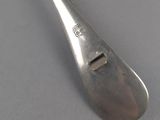 a silver spoon with a metal handle on a gray surface