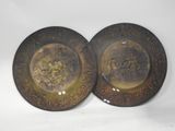 pair of antique brass plates with floral designs on them on a white background