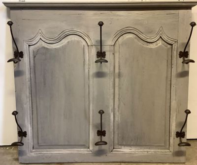 une image représentant une armoire grise à deux portes munies de poignées