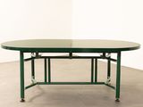 an image of a green table with a glass top and metal legs