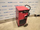 a red machine sitting in front of a wall