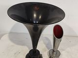 un vase noir et une coupe en argent posés sur une table