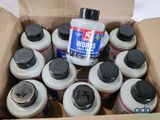a cardboard box filled with bottles of paint and a bottle of glue