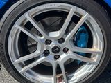 un gros plan sur un pneu d'une voiture bleue