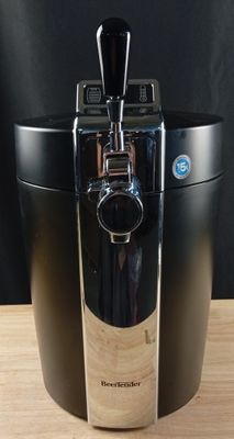 un distributeur de bière posé sur une table en bois