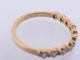 a close up of a gold ring with diamonds on a white surface
