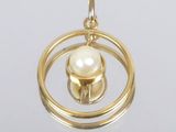 une image représentant un pendentif en or renfermant une perle