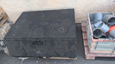 une boîte noire avec tout un tas de tuyaux posée sur une palette
