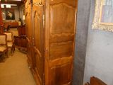 a large wooden armoire in a room with a painting on the wall