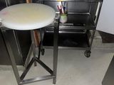 une petite table sur laquelle est posée une pizza, dans une cuisine