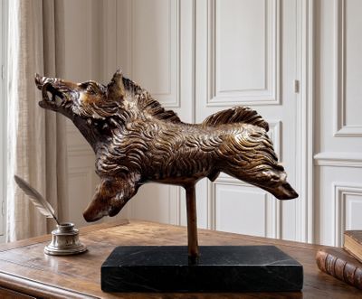 a statue of a dog on a desk with a pen and inkwell