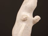 a white sculpture of a rat on a wooden table