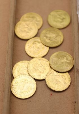 beaucoup de pièces d'or dans une boîte posée sur la table