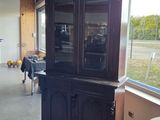 a black china cabinet in the middle of a room