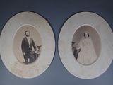 two old photos of a man and a woman on the wall