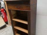 une armoire en bois avec des étagères, placée dans un coin de la pièce