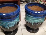 deux vases bleus posés par terre l'un à côté de l'autre